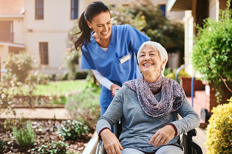 A respite care nurse wheels a patient around outside a nursing care facility in GreenAcres Place in Bossier City, LA